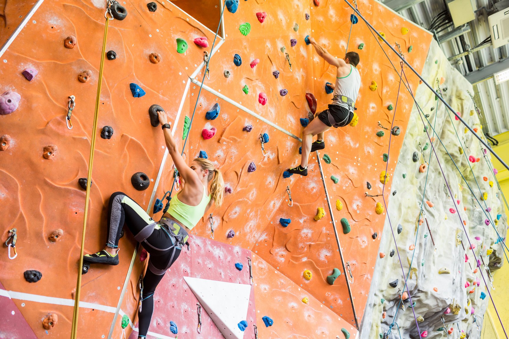 Fit couple rock climbing indoors